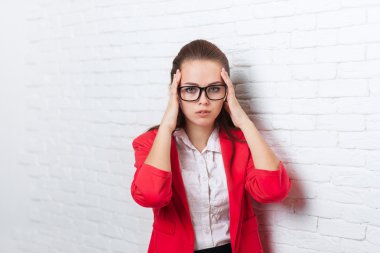 İş kadını tapınakların başını el ele tutuştu, ağrı, ağrı depresif kırmızı ceket gözlük giymek vurguladı