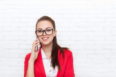 İş kadını mutlu gülümseme cep telefonu çağrı aşınma kırmızı ceket gözlük cep telefonunuzda konuşuyor