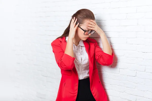 Businesswoman tenere le mani sulla testa, dolore, dolore depresso indossare occhiali giacca rossa stressato — Foto Stock