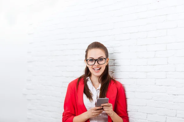 Geschäftsfrau benutzt Handy trägt rote Jacke Brille glückliches Lächeln — Stockfoto