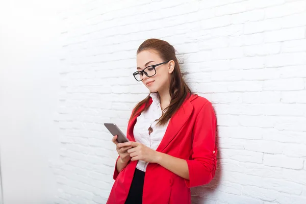 Businesswoman serious use cell smart phone wear red jacket glasses