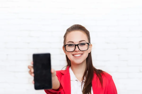Businesswoman show cell smart phone screen with empty copy space wear red jacket glasses happy smile — Stock Photo, Image