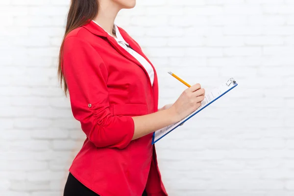 Kobieta interesu przytrzymaj folder ołówek pisać wear czerwona kurtka — Zdjęcie stockowe