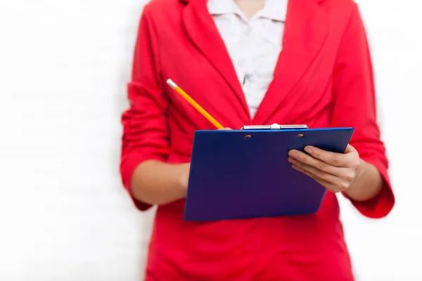 Femme d'affaires tenir dossier crayon écrire porter veste rouge — Photo