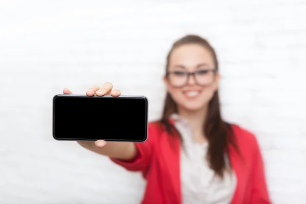 Mujer de negocios mostrar la pantalla del teléfono inteligente celular con espacio de copia vacío usar gafas chaqueta roja sonrisa feliz —  Fotos de Stock
