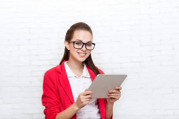 Geschäftsfrau nutzt Tablet-Computer trägt rote Jacke Brille glückliches Lächeln — Stockfoto