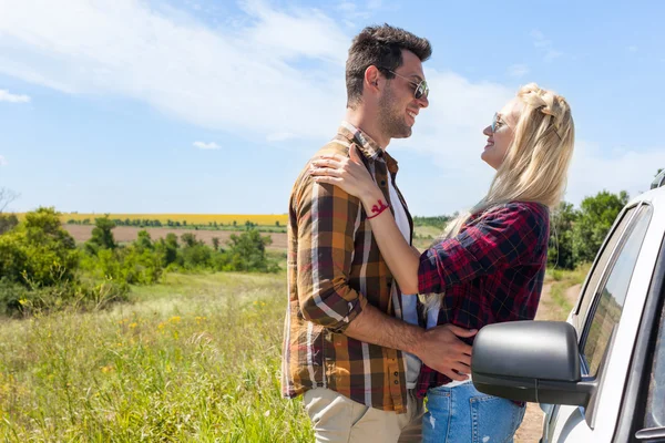 Couple love embrace looking face near car countryside road — Stock Photo, Image