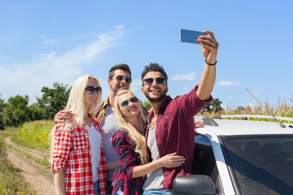Człowiek trzymać inteligentny telefon aparat fotograficzny biorąc selfie zdjęcie przyjaciół uśmiech wsi samochód — Zdjęcie stockowe