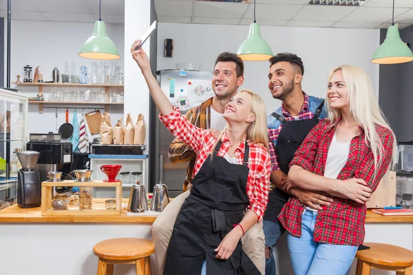 Las personas que toman fotos de amigos selfie café con barista sentado en el mostrador del bar, los hombres de raza mixta sostienen la sonrisa feliz de la mujer del teléfono inteligente —  Fotos de Stock