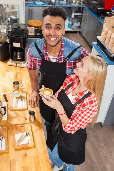 Barista taza café bar bar contador, mezclar raza hombre y mujer feliz sonrisa ángulo superior — Foto de Stock