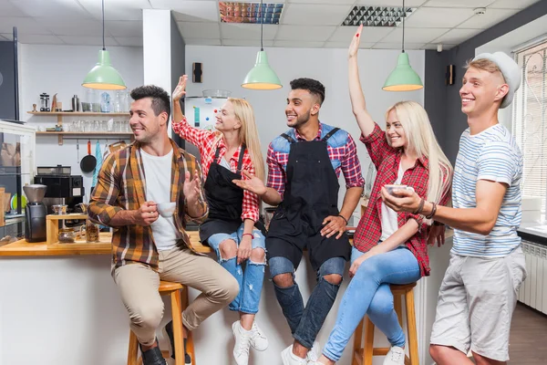 Persone amici bere caffè parlare ridendo con barista seduto al bancone del bar, mescolare gara uomo e donna sorriso felice — Foto Stock