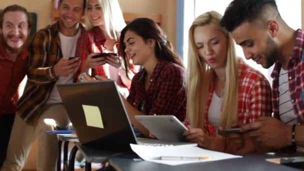 Studenci przy użyciu inteligentnego telefonu siedzącego biurko Szkoła ludzie Grupa uśmiech — Wideo stockowe