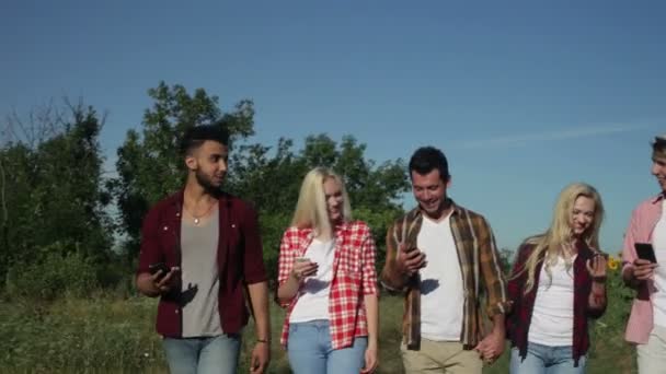 Amigos usando el teléfono inteligente charlando al aire libre caminando campo camino gente mensajería — Vídeos de Stock