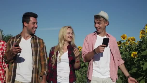 Amigos usando el teléfono inteligente charlando al aire libre caminando campo camino gente mensajería — Vídeo de stock