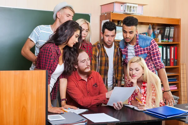 Étudiants qui regardent le document papier avec le professeur — Photo