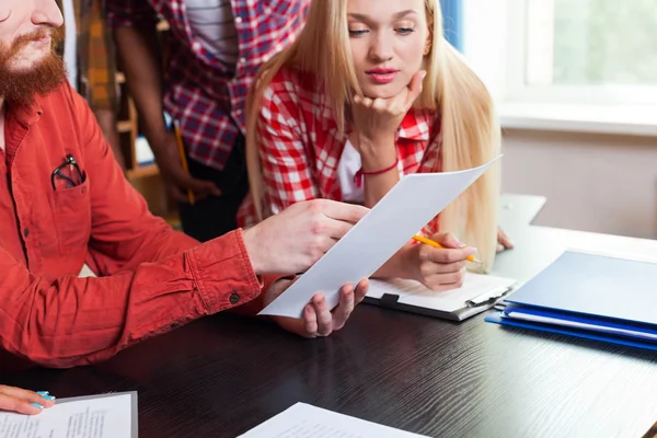 Fermer Groupe d'élèves du secondaire regardant un document papier avec le professeur assis au bureau, les jeunes enseignants discutent — Photo