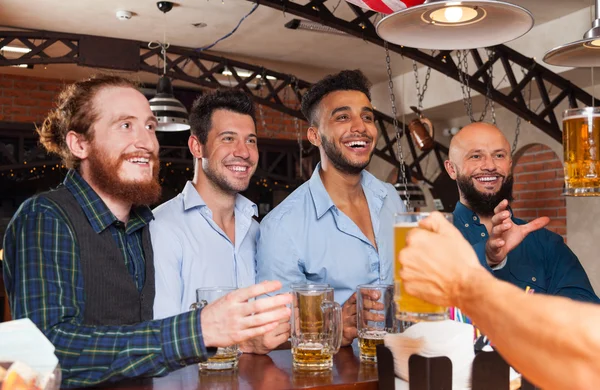 Man Group In Bar Segure copos de cerveja, De pé na contra-ordem Barman, Misture raça amigos alegres — Fotografia de Stock