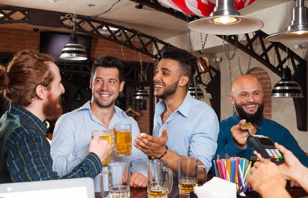 Hombre Grupo En Bar Bebiendo Cerveza, Mix Race Friends Reunión, Barbudo Hombre Pago con tarjeta de crédito —  Fotos de Stock