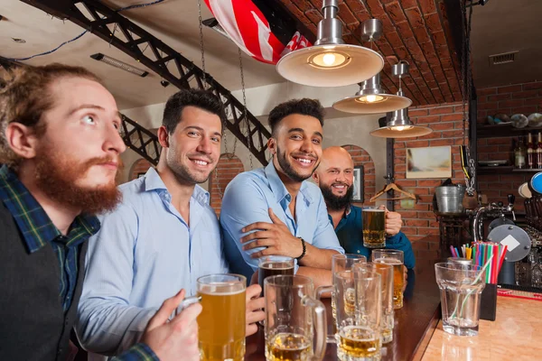 Hombre grupo en bar celebrar vasos feliz sonrisa, beber cerveza, mezclar raza alegre amigos reunión —  Fotos de Stock