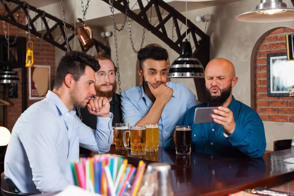 Hombre grupo en bar beber cerveza, frustrado chico celebrar teléfono inteligente celular —  Fotos de Stock