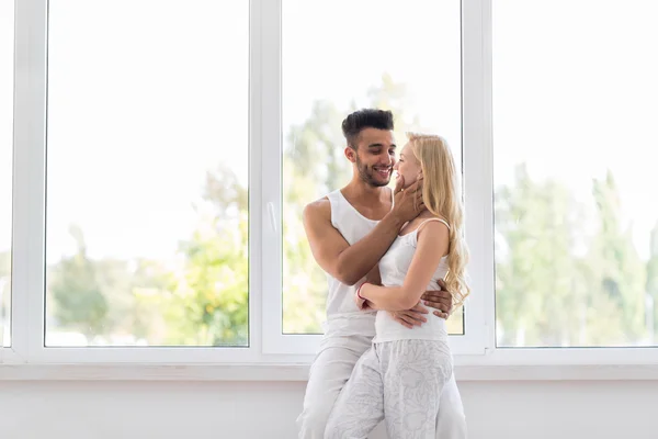 Young Beautiful Couple Stand Near Big Window Embrace Kissing, Happy Hispanic Man And Woman — Stock fotografie