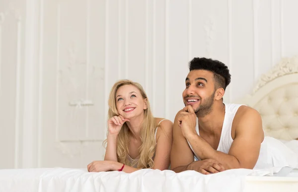 Pareja joven acostada en la cama, feliz sonrisa Hombre y mujer hispanos amantes en el dormitorio —  Fotos de Stock