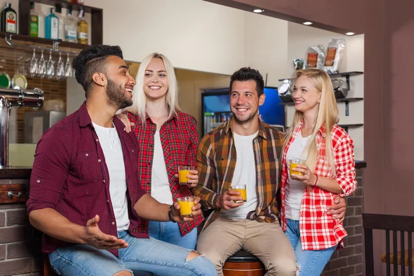 Mensen vrienden drinken sinaasappelsap praten lachen zittend op Bar teller, mix race man en vrouw paar — Stockfoto