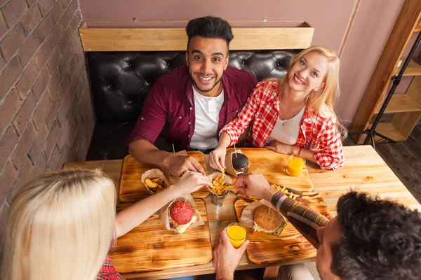 패스트 푸드 햄버거 감자를 먹는 사람들 그룹 카페 상단 각도보기에 나무 테이블에 앉아 — 스톡 사진