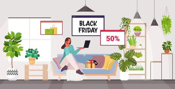 Žena pomocí notebooku on-line nakupování černá pátek velký prodej dovolená slevy koncept obývací pokoj interiér — Stockový vektor
