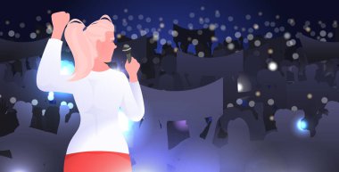 Elinde mikrofonlu bir kadın sahne kadınları kulübünden seyircilere sesleniyor. Birbirlerini destekleyen feministler birliği.