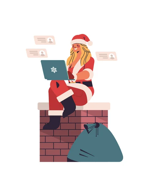 Donna in costume Babbo Natale seduto sul camino e utilizzando il computer portatile Capodanno felice festa di Natale — Vettoriale Stock