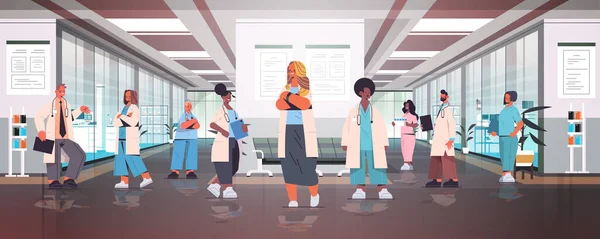 Ομάδα των γιατρών αγώνα μείγμα με στολή στέκεται μαζί στο νοσοκομείο διάδρομο ιατρική έννοια υγειονομικής περίθαλψης — Διανυσματικό Αρχείο