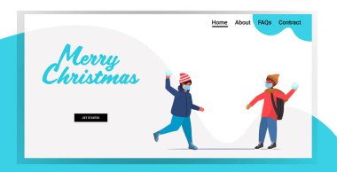 Kar topu atan maskeli çocuklar kış eğlencesine dışarıda vakit geçiriyorlar ve koronavirüs karantinası yapıyorlar.