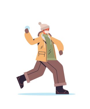 Kar topu atan maskeli adam kış eğlencesi yapıyor. Açık hava aktiviteleri, koronavirüs karantina konsepti.