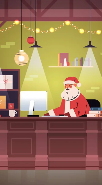 Babbo Natale seduto sul posto di lavoro e utilizzando il computer Buon Natale felice anno nuovo festa — Vettoriale Stock