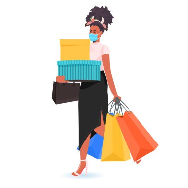 Noel Baba şapkalı bir kadın alışveriş torbası tutuyor Coronavirus salgınını önlemek için maske takan bir kız.