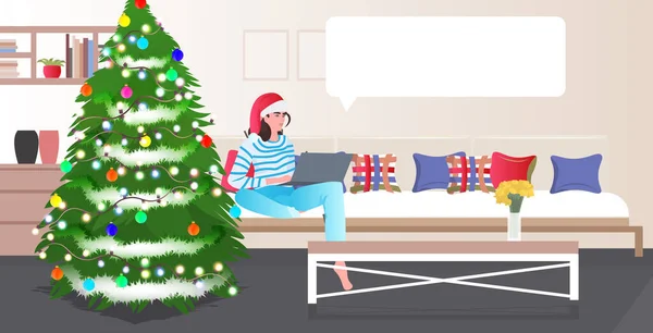Žena v Santa klobouk pomocí notebooku chat bublina komunikace Nový rok dovolená oslava koncept — Stockový vektor