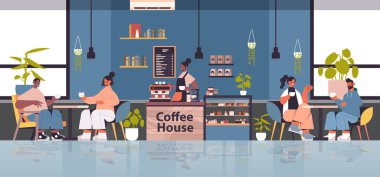 Üniformalı kadın barista önlüklü garsonda çalışıyor yarış müşterilerine kahve yapıyor.