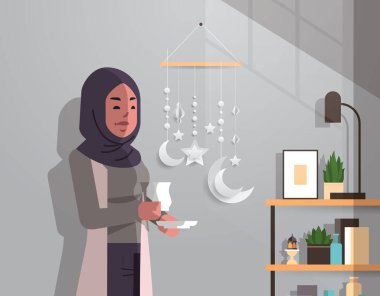 Geleneksel giysiler içindeki Arap kadın Ramazan Kareem 'i kutluyor. Kutsal ay modern oturma odası, düz, dikey portre.