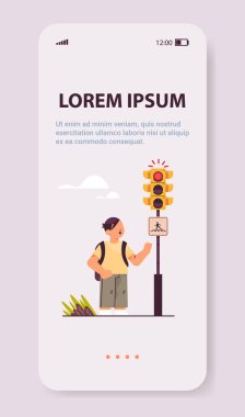 Sırt çantalı okul çocuğu yaya geçidi güvenlik kavramını dikey olarak geçmek için yeşil ışık bekliyor.