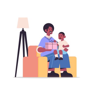 Afrikalı Amerikalı baba, oğluna hediye paketi almış. Babalık konsepti. Baba çocuğuna tatil hediyesi veriyor.