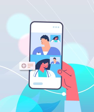 Hasta, video görüşmesi sırasında akıllı telefon ekranlarında doktorlarla konuşuyor. Çevrimiçi danışmanlık sağlık hizmetleri
