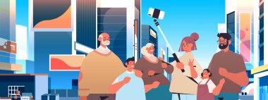 Özçekim çubuğu kullanan ve akıllı telefon kamerasında fotoğraf çeken çok nesilli bir aile.