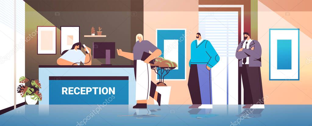 business people customers or travelers standing at reception desk and talking to receptionist