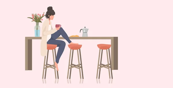 Güzel bir kadın, kahve içen bir kız mutfak tezgahındaki taburede oturuyor. — Stok Vektör