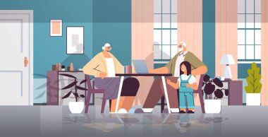 Torunu olan büyükannesi ve büyükbabası dizüstü bilgisayar sosyal medya ağını online iletişim konsepti oturma odası iç mekanını kullanıyor.