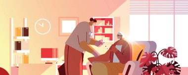 Yaşlı hastaya aşı yapan doktor Coronavirus aşısına karşı savaşan yaşlı kadına iğne yapıyor.