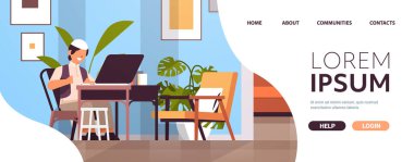 İşyerindeki Arap okul çocuğu dizüstü bilgisayar kullanıyor. Ev ödevi eğitimi alan Arap çocuk. Oturma odası iç mekanı.