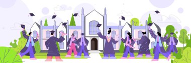 Üniversite binasının yakınına şapka atan mezun öğrenciler akademik diploma eğitimini kutluyorlar.