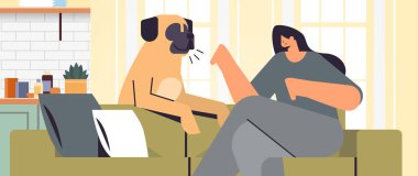 Genç bir kadın köpek sahibi ve evcil hayvan konsepti olan sevimli bir evcil hayvanla vakit geçiriyor.